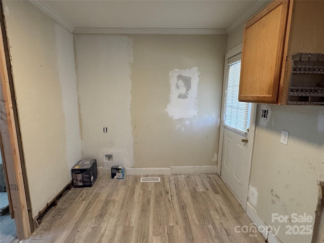 laundry area featuring light wood-type flooring, cabinets, and crown molding