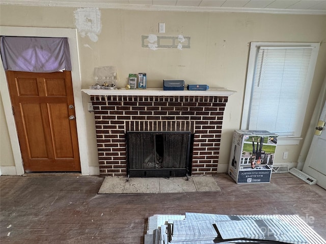 interior details featuring a brick fireplace and crown molding