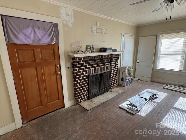 living room with light wood-type flooring, a brick fireplace, crown molding, and ceiling fan