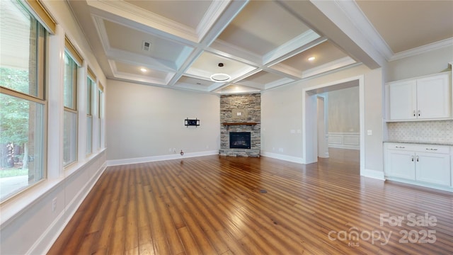 unfurnished living room featuring beam ceiling, a wealth of natural light, dark hardwood / wood-style floors, and coffered ceiling