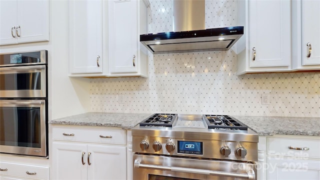 kitchen featuring decorative backsplash, white cabinetry, wall chimney exhaust hood, and stainless steel appliances