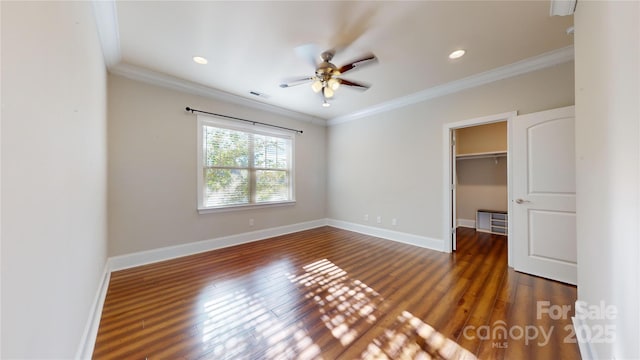 unfurnished bedroom featuring a walk in closet, ceiling fan, a closet, and crown molding