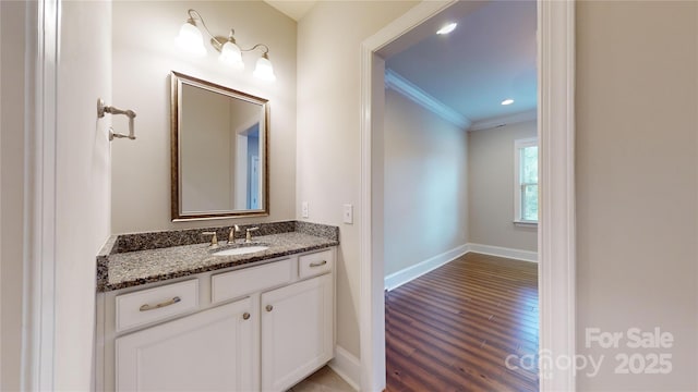 bathroom featuring hardwood / wood-style floors, vanity, and ornamental molding