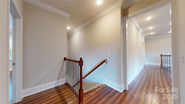 stairway with wood-type flooring and ornamental molding