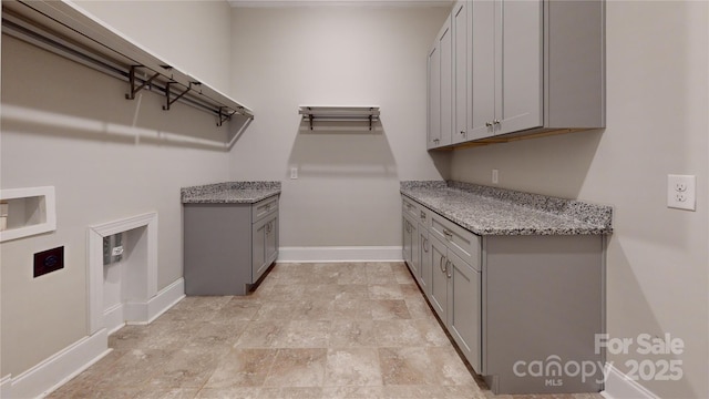 washroom featuring hookup for a washing machine and cabinets