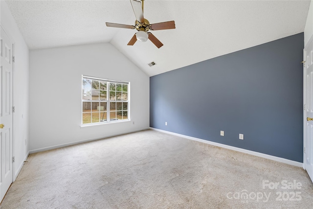 spare room with ceiling fan, light colored carpet, and lofted ceiling