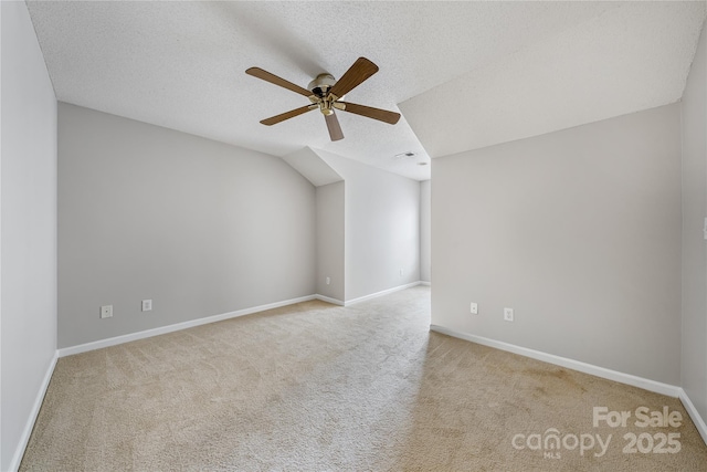 bonus room featuring ceiling fan, light colored carpet, lofted ceiling, and a textured ceiling