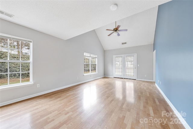 unfurnished room featuring a textured ceiling, light hardwood / wood-style flooring, high vaulted ceiling, and ceiling fan