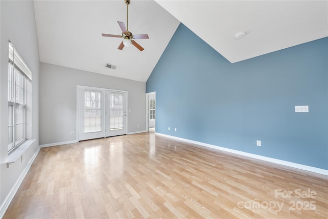 empty room with high vaulted ceiling, light hardwood / wood-style floors, and ceiling fan