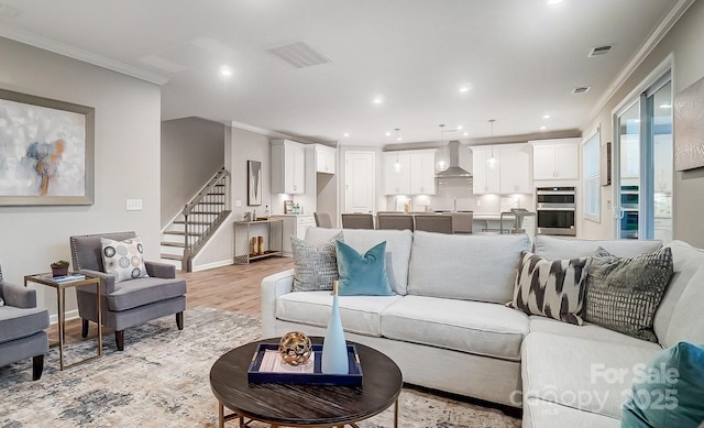 living room with light hardwood / wood-style floors and ornamental molding