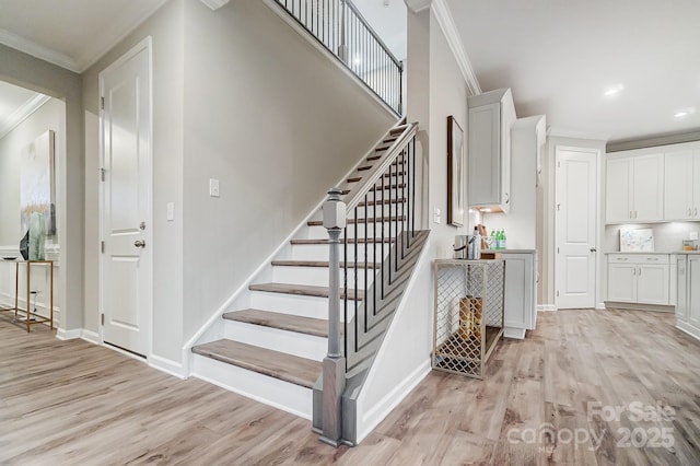 stairway featuring ornamental molding and wood-type flooring