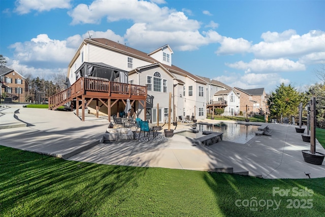 rear view of house featuring a deck, a patio area, and a yard