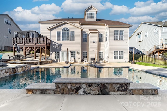 rear view of property with a patio area, a swimming pool side deck, and pool water feature