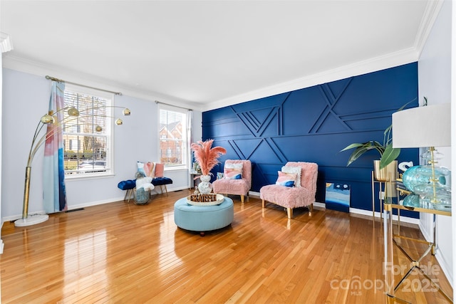 living area with ornamental molding and hardwood / wood-style flooring