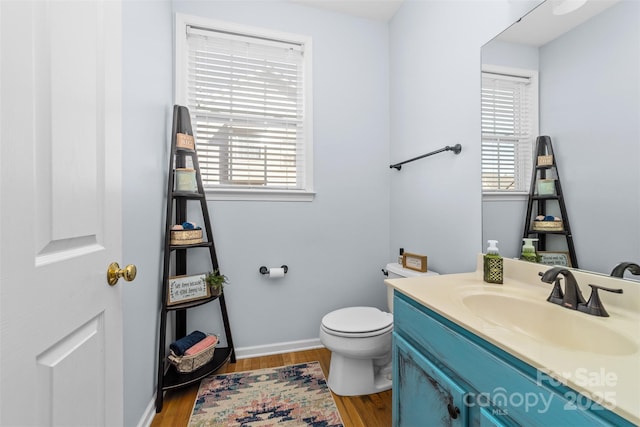 bathroom featuring toilet, vanity, and hardwood / wood-style floors