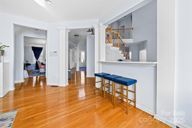 dining space with wood-type flooring and ornate columns