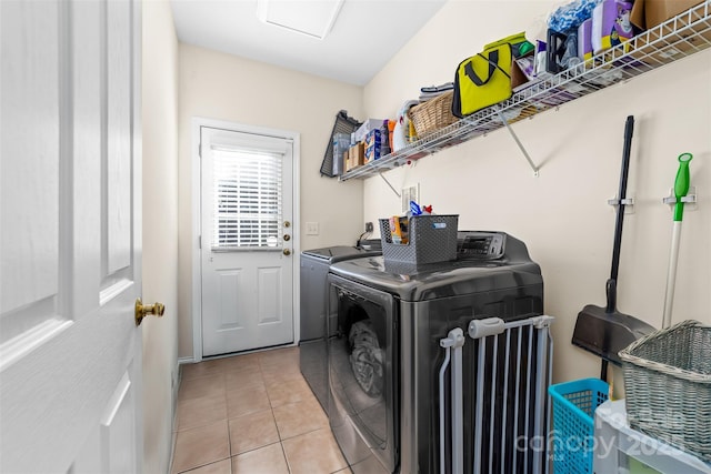 clothes washing area with light tile patterned floors and washing machine and clothes dryer