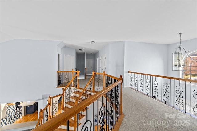 corridor with a chandelier and carpet floors