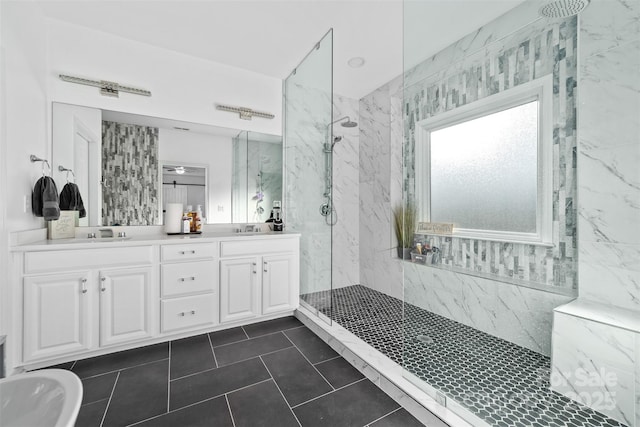 bathroom featuring tiled shower, vanity, and tile patterned flooring