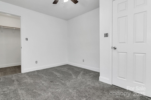 unfurnished bedroom featuring dark colored carpet and ceiling fan