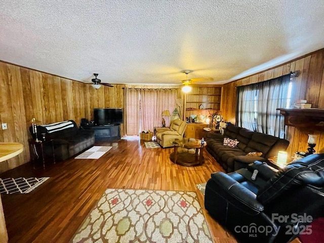 living room featuring a textured ceiling, hardwood / wood-style flooring, and ceiling fan