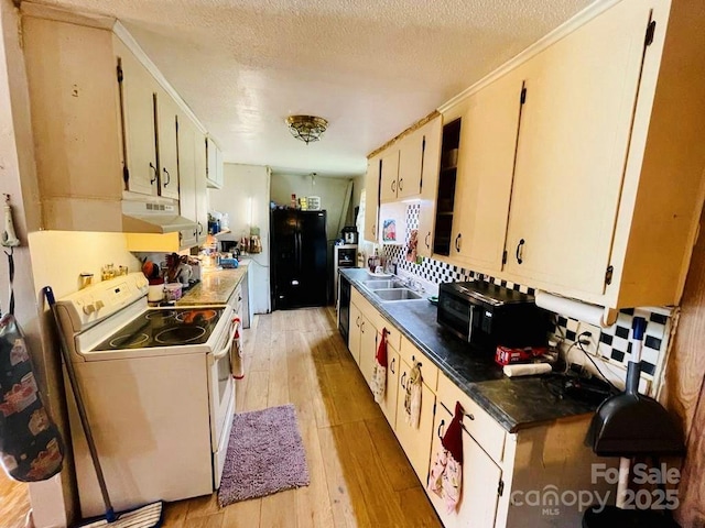 kitchen with black refrigerator, white electric range, sink, light hardwood / wood-style flooring, and a textured ceiling