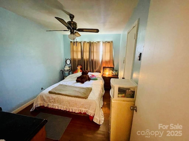 bedroom with dark hardwood / wood-style flooring and ceiling fan