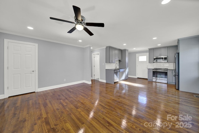 unfurnished living room with sink, crown molding, dark wood-type flooring, and ceiling fan