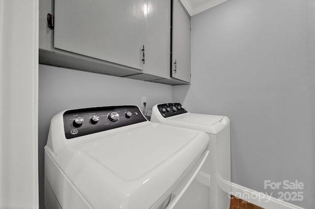 laundry room featuring cabinets, ornamental molding, and washer and clothes dryer