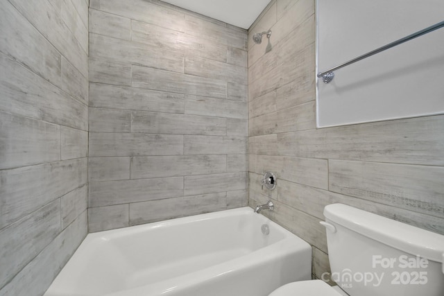 bathroom featuring tiled shower / bath and toilet