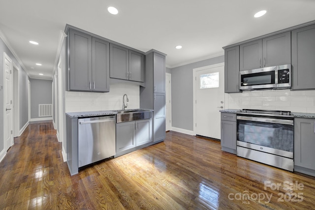 kitchen featuring sink, crown molding, gray cabinetry, stainless steel appliances, and light stone countertops