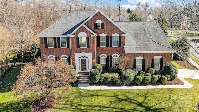 colonial-style house featuring a front yard