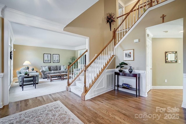 staircase featuring ornamental molding and wood-type flooring