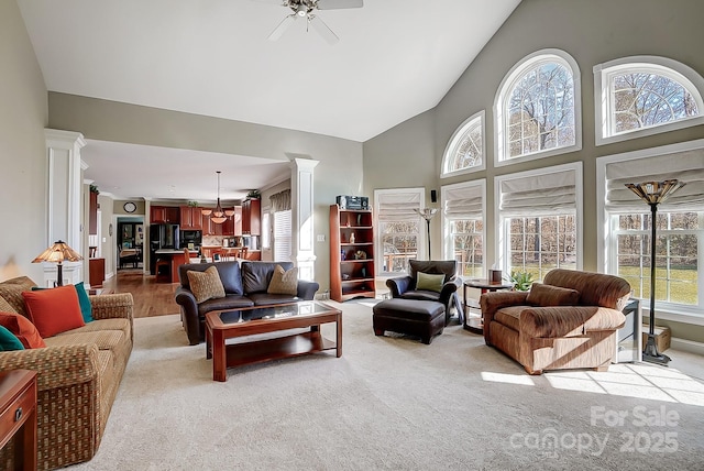 carpeted living room featuring high vaulted ceiling and ceiling fan