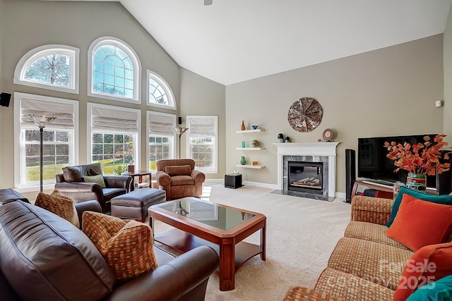 living room featuring light colored carpet, a premium fireplace, and high vaulted ceiling