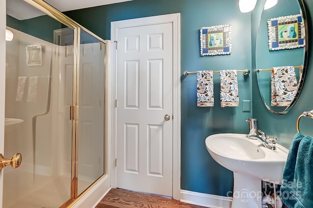 bathroom with a shower with door and hardwood / wood-style floors