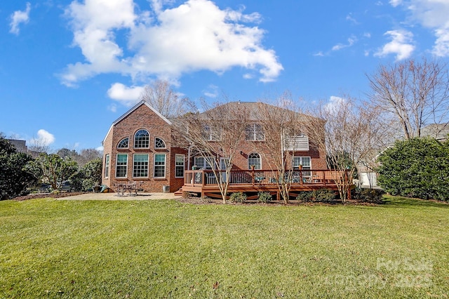 rear view of house featuring a patio area, a lawn, and a wooden deck