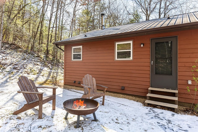 snow covered patio featuring a fire pit