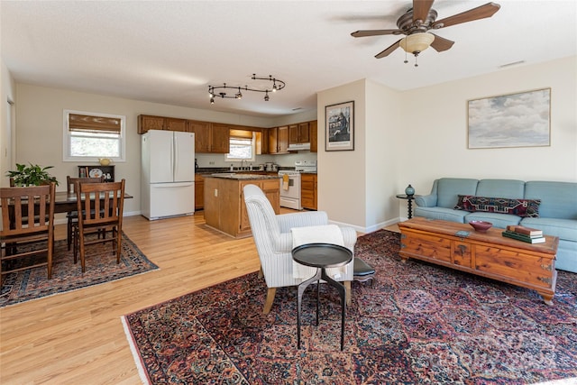 living room with ceiling fan, a healthy amount of sunlight, sink, and light hardwood / wood-style flooring