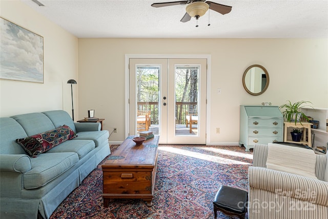 living room featuring ceiling fan, french doors, and a textured ceiling