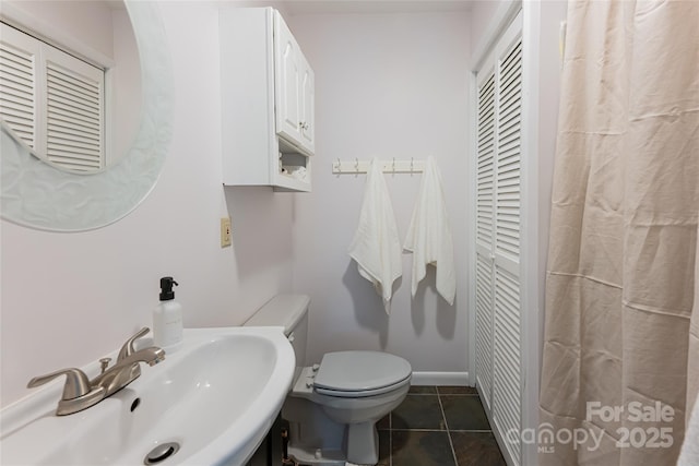 bathroom featuring sink, tile patterned floors, and toilet