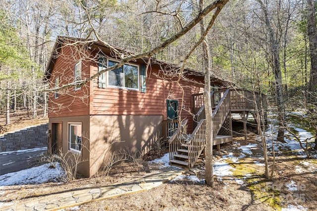 view of property exterior featuring a deck with water view