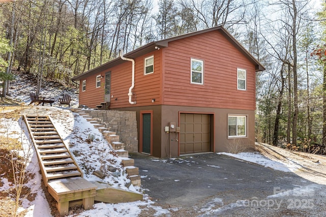 view of snowy exterior featuring a garage