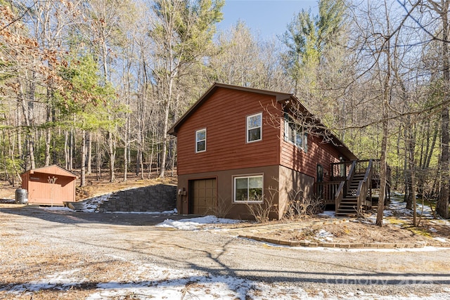 view of side of home with a garage and a wooden deck