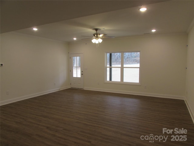 empty room featuring ceiling fan, dark wood-type flooring, and ornamental molding