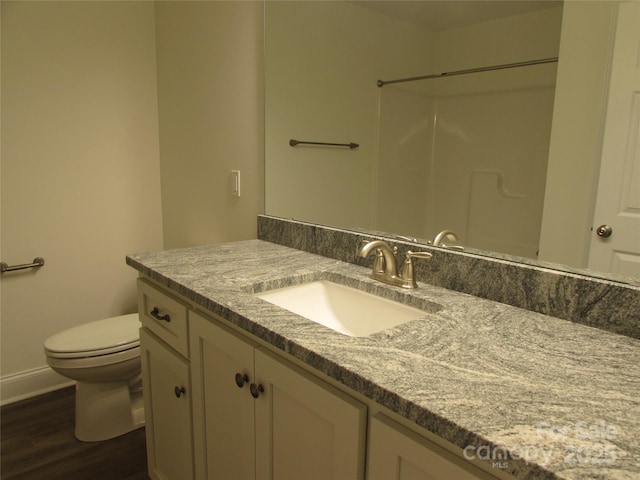 bathroom featuring a shower, hardwood / wood-style floors, vanity, and toilet