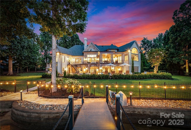 back house at dusk with a balcony