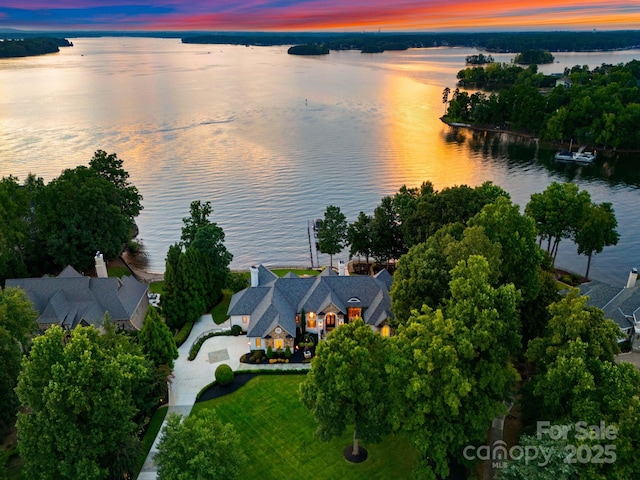 aerial view at dusk featuring a water view