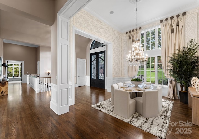 dining area featuring a healthy amount of sunlight, french doors, crown molding, and an inviting chandelier