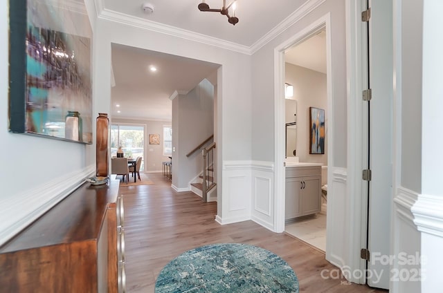 hall featuring ornamental molding and light hardwood / wood-style floors